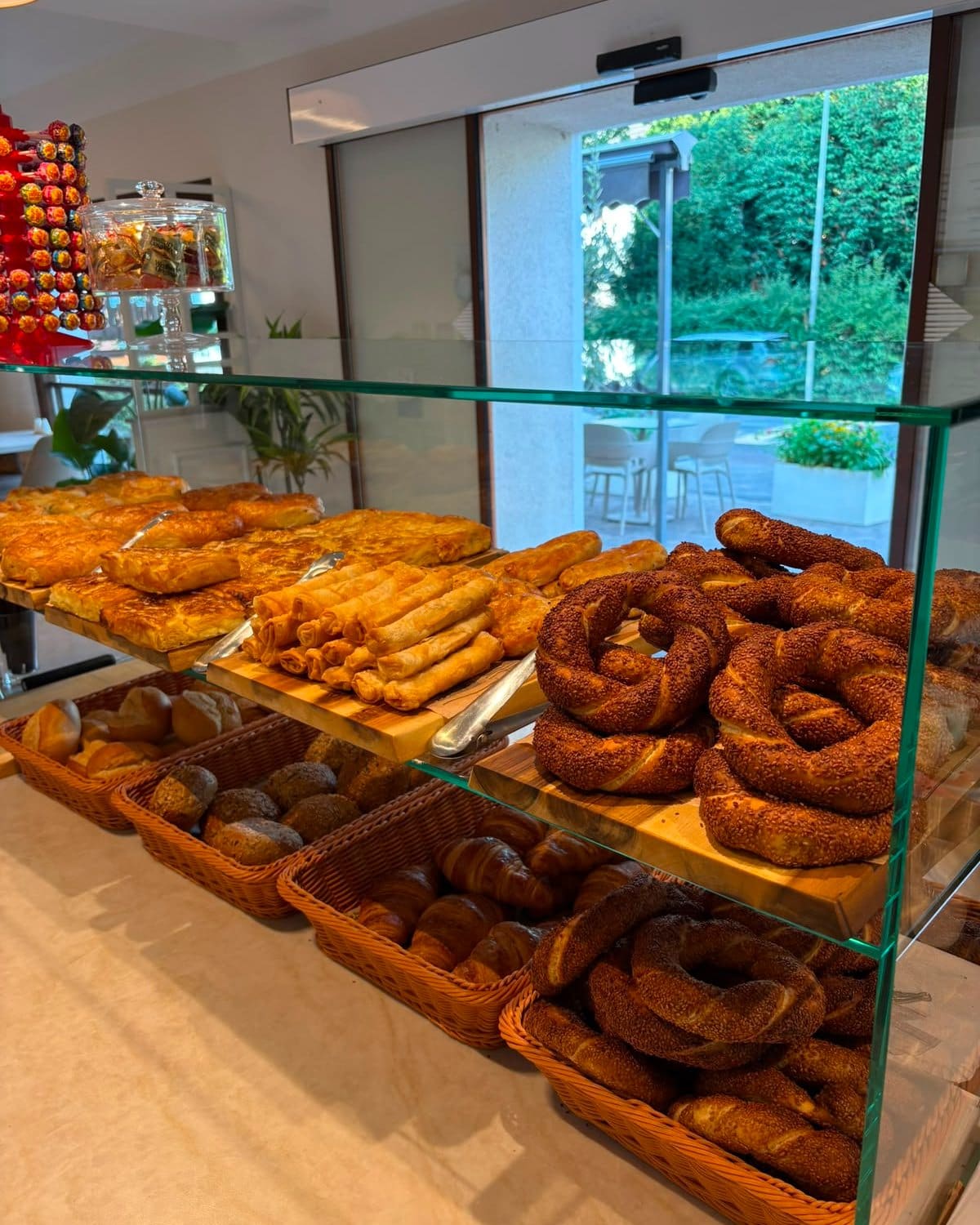 Frische Simit auf einem Holzbrett vor der Auslage des Café Ava